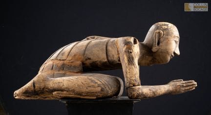 缅甸，19-20世纪。
一名僧人跪地祈祷，双手合十虔诚叩拜。
木质，留有漆痕，表面呈现优美的风化痕迹