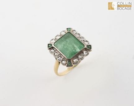 Goldring mit einem Smaragd in der Mitte, der von v