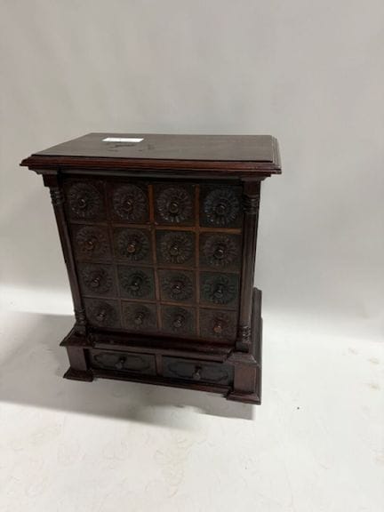A cabinet with drawers made of exotic wood, molded