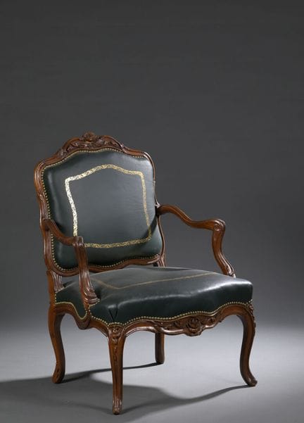 Fauteuil à dossier plat en noyer mouluré et sculpt