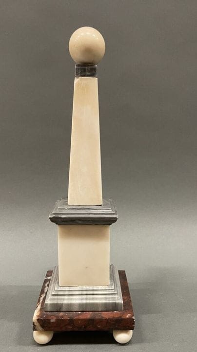 Polychrome marble obelisk. 
H: 31 cm
Minor chips