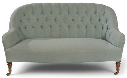 Victorian-style sofa with turned legs and a tufted