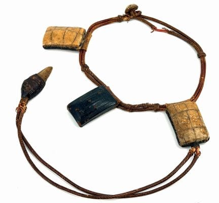 ÁFRICA. 
Collar con amuletos. 
Cuero, fibra. 
Long