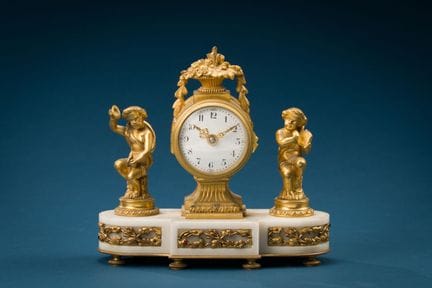 Small clock decorated with musical cupids.
Louis X