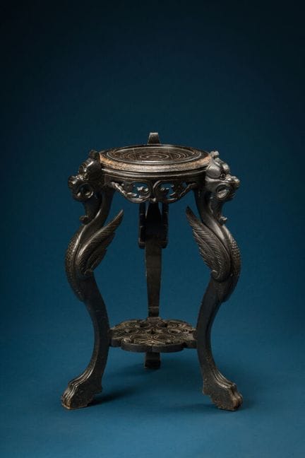 Blackened wooden tripod stool decorated with chime