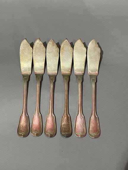 SEIS CUCHILLOS para pescado de metal plateado.