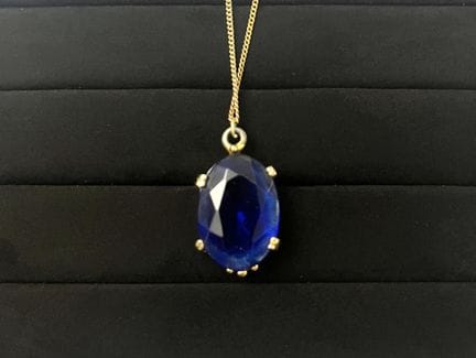A gold-plated metal chain featuring a pendant with