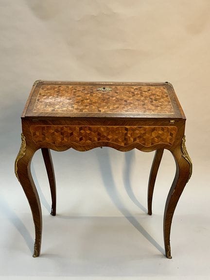 Flap-top secretary desk made of veneered wood.
Lou