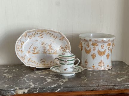 A SHAKY CUP with handles and its PORCELAIN SAUCER,