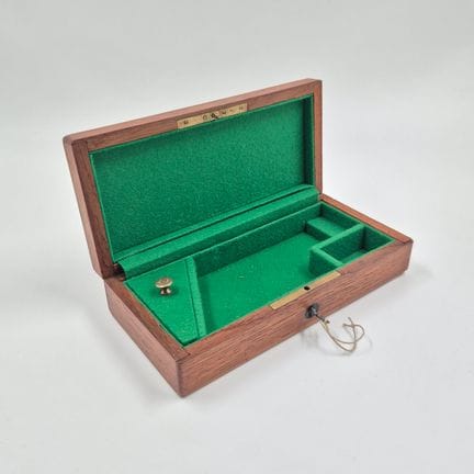 Walnut revolver case with a brass handle, lined on
