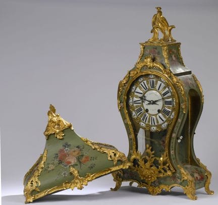 Reloj de pared con su consola de forma festoneada,