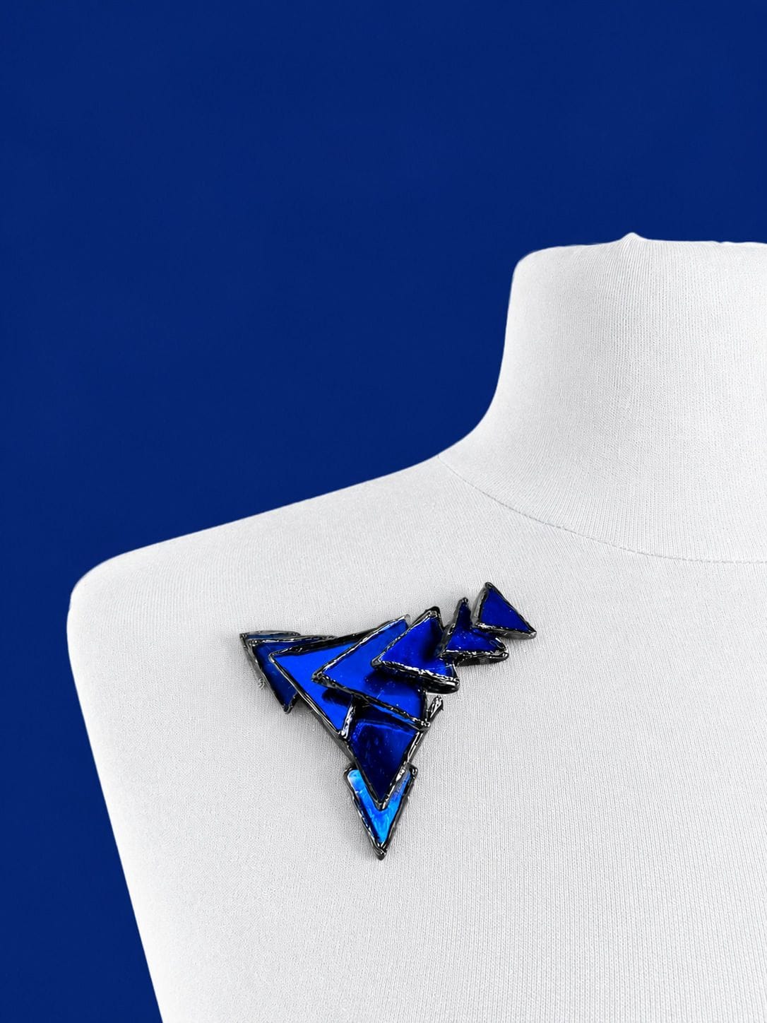 IRENA JAWORSKA Brooch with triangular motifs in black resin and blue mirror—monogrammed
8.5 x 6.5 cm