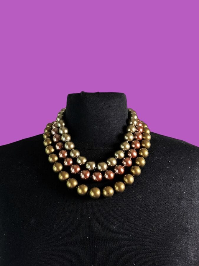 CHANEL Made in France  Collier à fermoir en métal doré à 3 rangs de perles nacrées dorées et brunes - signé
Ht 25 cm
(petites usures de nacre)