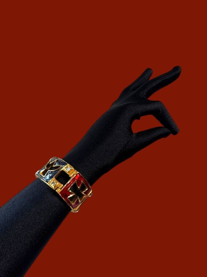 CHRISTIAN LACROIX Made in France Patterned bracelet in openwork gold-tone metal with red and blue enamel and rhinestones—signed. Length: 15.5 cm