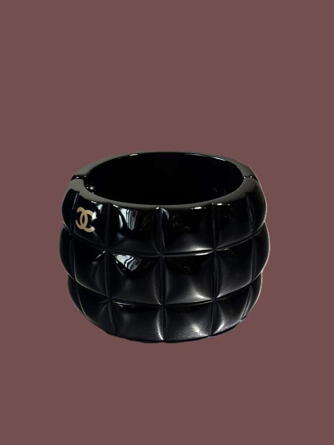 CHANEL Made in France Bracelet manchette articulé en résine noire matelassée au sigle de la marque - signé 
5,5x5,8 cm