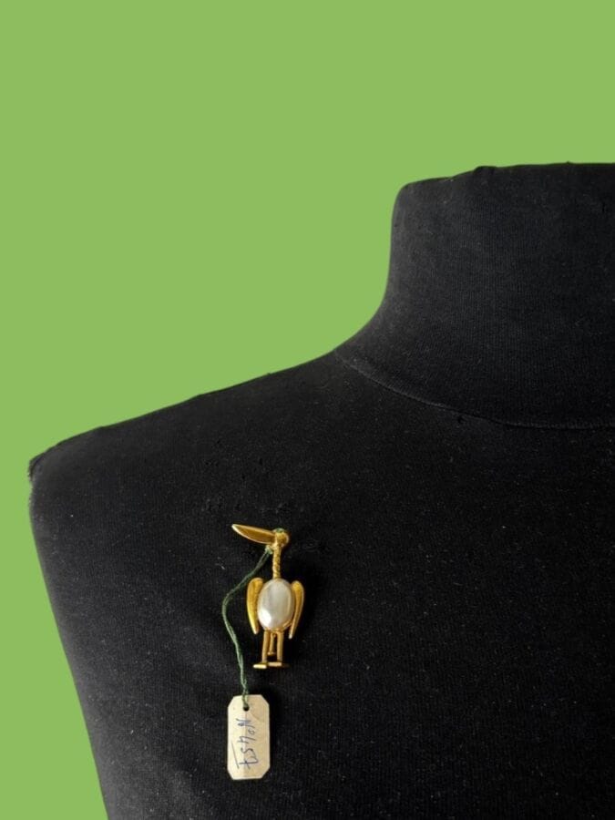 PAUL WIEGANT Gold-plated metal bird brooch with a pearlescent pearl and a small green rhinestone   - unsigned  stock label                                                                             Height: 4 cm