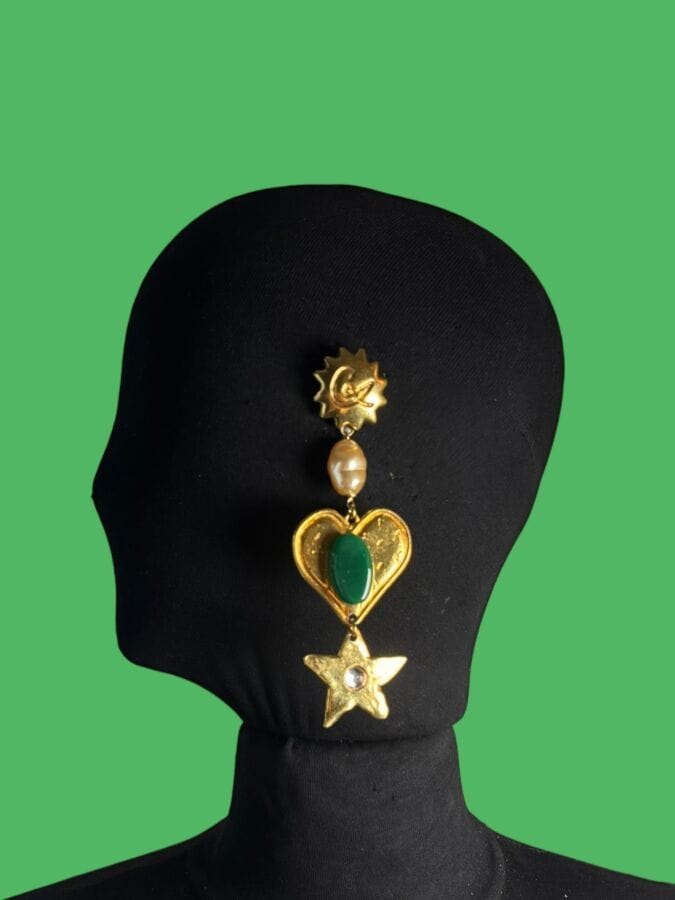 CHRISTIAN LACROIX Made in France Single-clip sun-shaped earring with heart- and star-shaped pendants in gold-plated metal, a baroque pearlescent pearl, a green glass paste pebble, and rhinestones—signed
Height: 12 cm