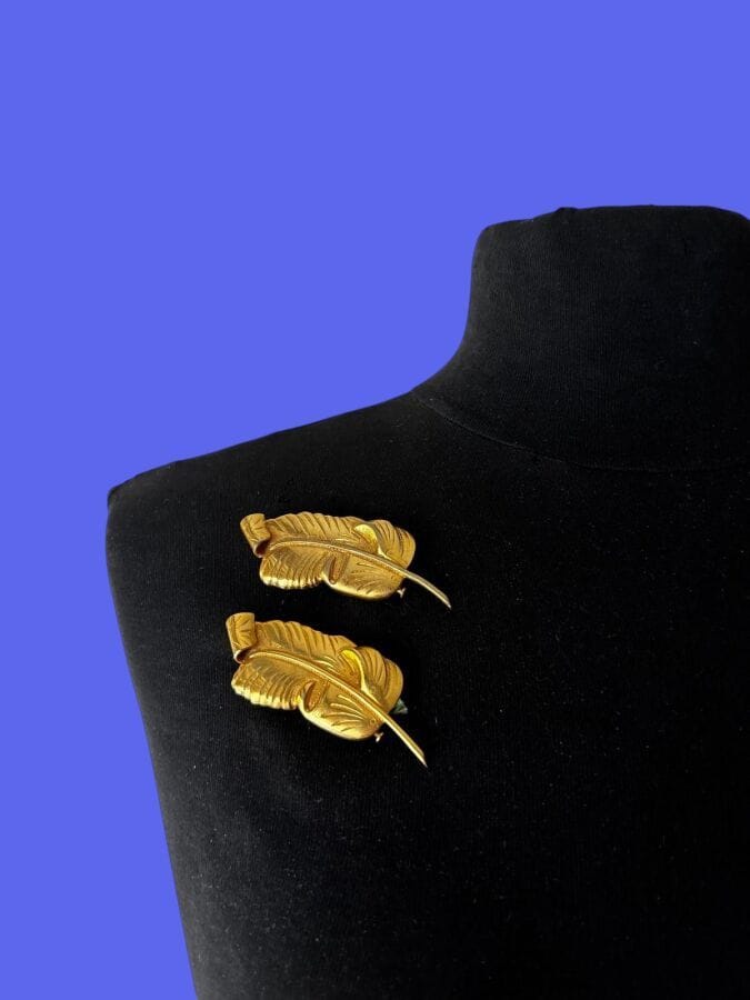 PAUL WIEGANT Paire de  broches plume en métal doré - non signée étiquette de stock 
Ht 6,5 cm