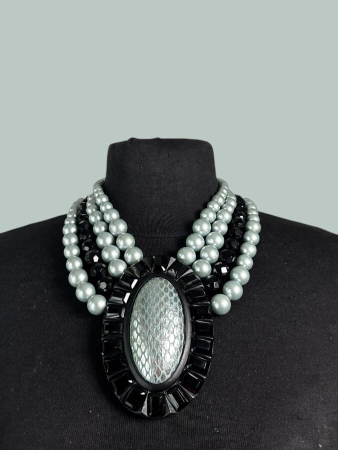 APARTMENT FOR RENT: Patinated steel necklace with 4 rows of blue pearl-like beads and faceted black glass, featuring a central medallion motif—signed, with original box
Length: 43 cm