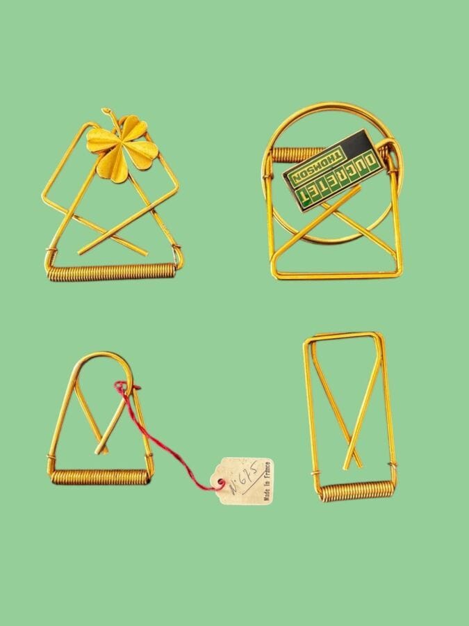 PAUL WIEGANT Five spring-loaded gold-plated metal money clips, including one Ducretet Thomson promotional item—unsigned, with stock label