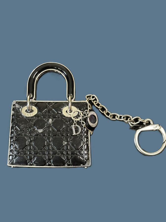 CHRISTIAN DIOR Bijou de sac Lady Dior en métal chromé et cuir noir - signé et monogrammé
9x6,5 cm
(une petite usure)