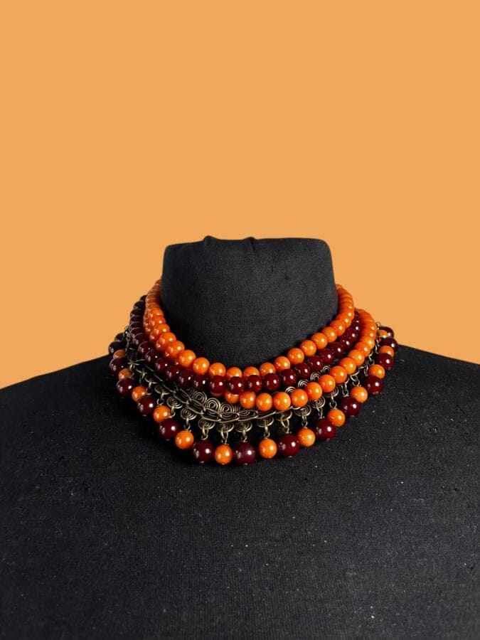 BABYLONE PARIS Collier de chien en métal patiné et perles de verre orange et rouge                                                   Longueur  réglable 42 cm                                                                                                                                                     On y joint un Collier de feuilles  en laiton doré et patiné - non signé                                                                                      Longueur 40 cm