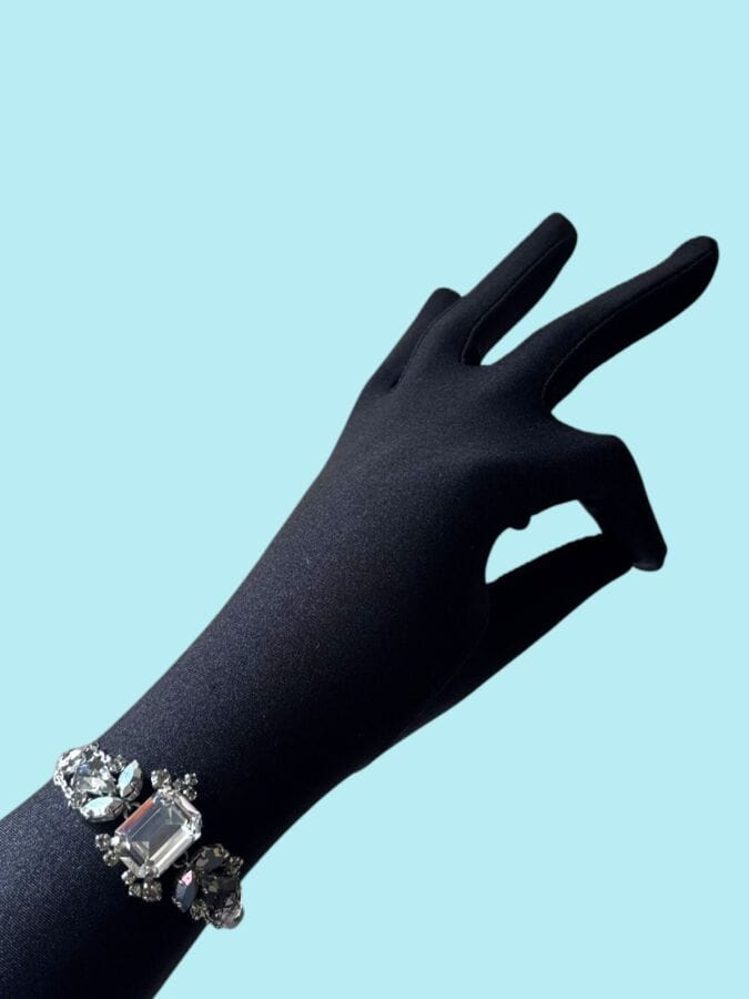 CHRISTIAN DIOR by JOHN GALLIANO  Bracelet in white gold-patinated metal with a pattern of smoky and translucent rhinestones—signed and featuring a monogram charm on the clasp (same as the previous lot)
Length: 19 cm