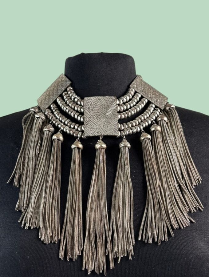 KENZO PARIS Ethnically inspired draped necklace in silver plated metal with guilloché patterns, rows of pearls, and fringed tassels  — signed and with stock tag 
Length: 37 cm
Height of motif: 18 cm
