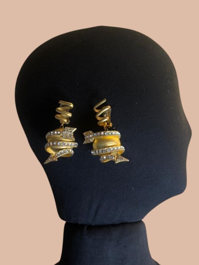 VERSACE par UGO CARREANI Paire de clips d'oreilles tourbillon à sphère fléchée en métal doré satiné  et strass - non signée
Ht 6,5 cm