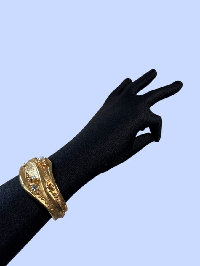 CHRISTIAN LACROIX Made in France Bracelet vague rigide ouvert en métal doré et strass  - signé
Largeur intérieure : 6 cm