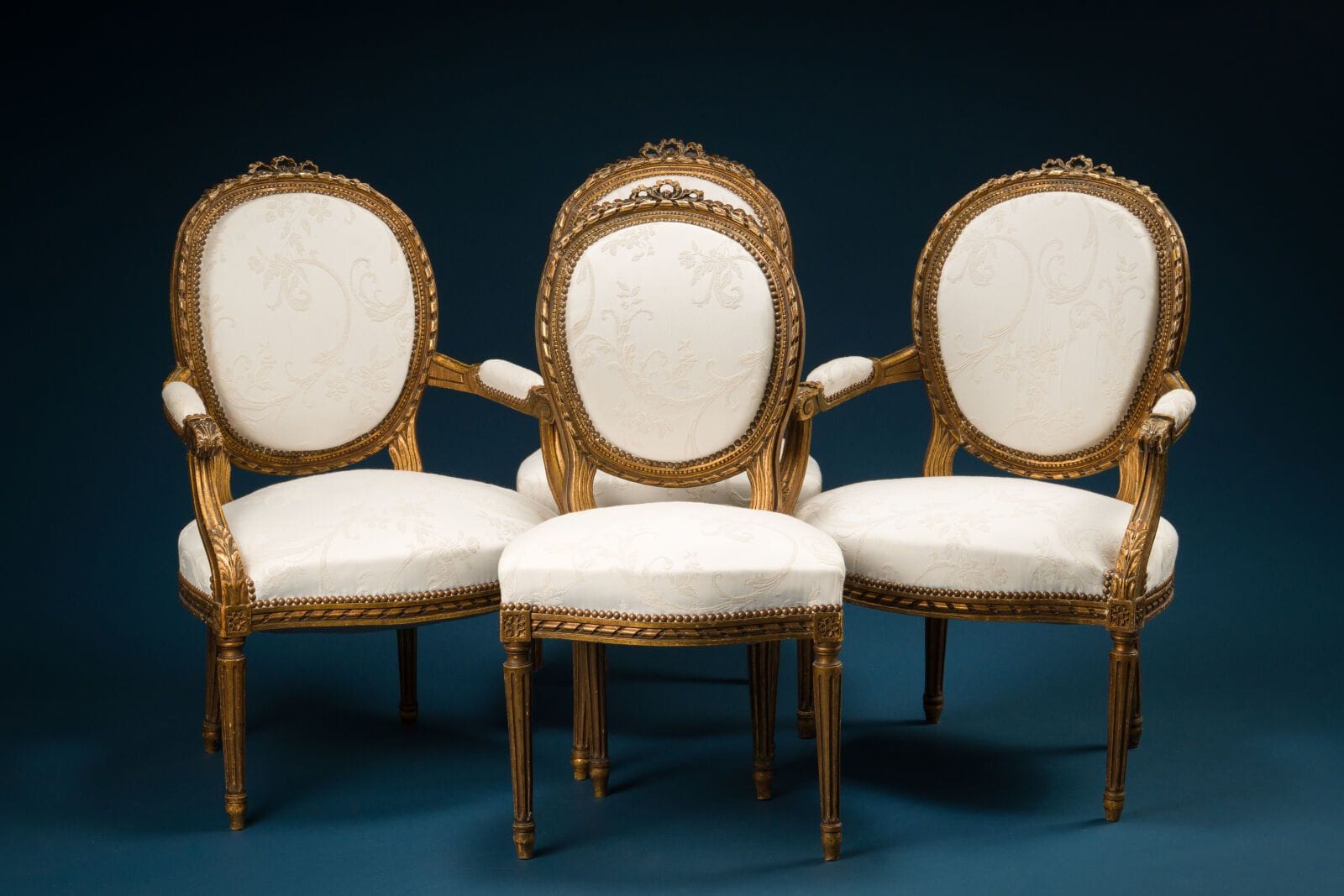 Living room set consisting of a pair of armchairs and chairs made of molded, carved, and gilded wood, with medallion-shaped backs and a design featuring ribbon-wrapped reeds and bows
Louis XVI style
H.: 92 cm; W.: 61 cm; D.: 62 cm.
(Damage to the leg of one chair).