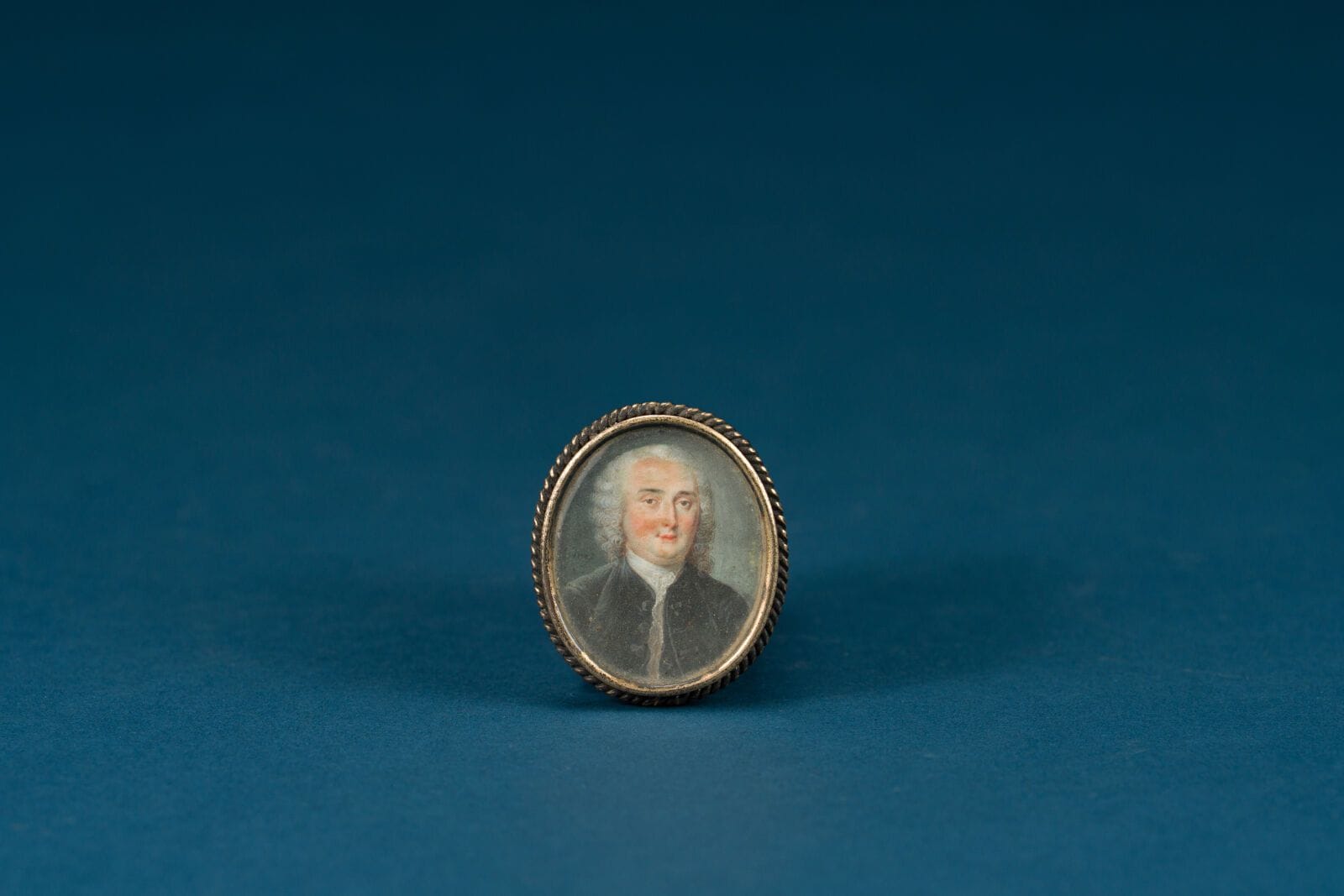 18th-Century French School 
"Man in a Red Frock Coat"
Oval miniature 
 3 x 2.5 cm.