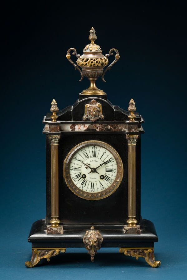 Black marble and gilded bronze grandfather clock with column decoration.
Designed by F. HAMON. 
Late 19th century.
Height: 47 cm.