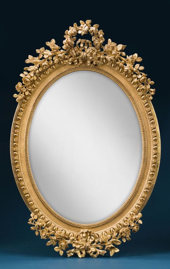 Large oval mirror made of wood and gilded plaster, decorated with ovals and flowering branches. 
Napoleon III period 
Height: 120 cm; Width: 80 cm.