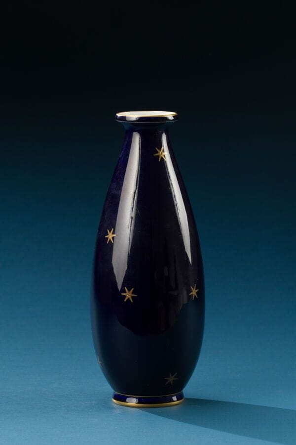 SEVRES, 1927 
Porcelain shell-shaped vase decorated with stars on a deep blue background. 
Marked on the base. 
Height: 33 cm.