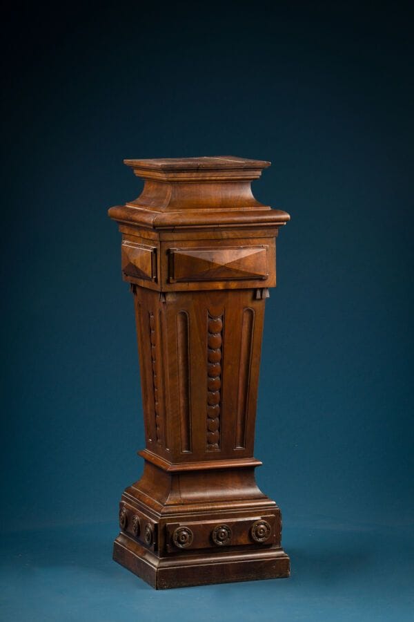 Wooden case carved with medallions and rosettes.
Late 19th century.
H.: 107 cm; W.: 37 cm; D.: 37 cm. 
(Cracks)