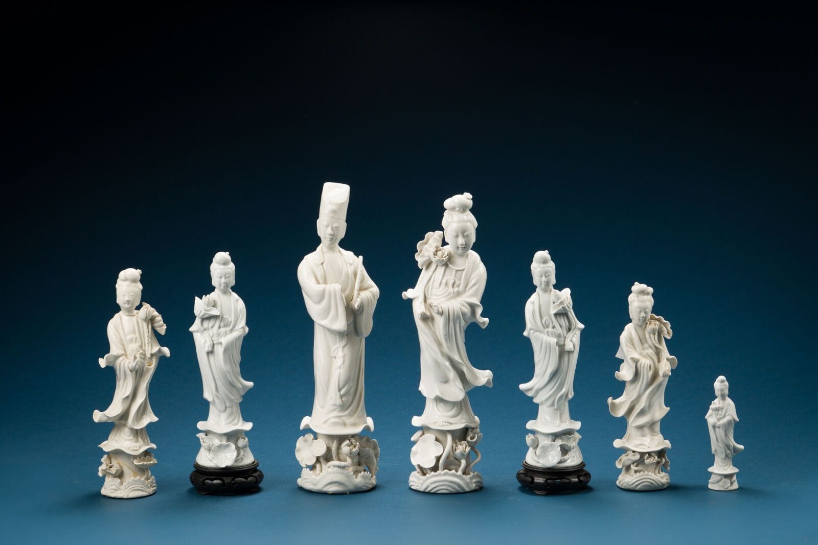 China, 19th century
Set of seven white porcelain Guanyin figures
Height (of the tallest): 31 cm. 
(damage; one hand is missing)