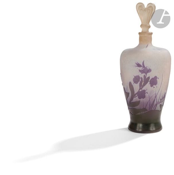 ÉTABLISSEMENTS GALLÉ (1904-1936) 
Giroflées des murailles
Flacon balustre méplat ; le bouchon cordiforme possiblement rapporté. Le corps du flacon en verre multicouche au décor, dégagé à l'acide, traité violet et vert sur fond gris ; le bouchon en verre moulé-pressé. Un éclat au col et sur le bouchon. Signé GALLÉ à l'étoile, en réserve gravé en camée à l'acide vers la base et porte une étiquette Cristallerie d'art Émile Gallé Nancy Paris sous la base. H. 21,5 cm