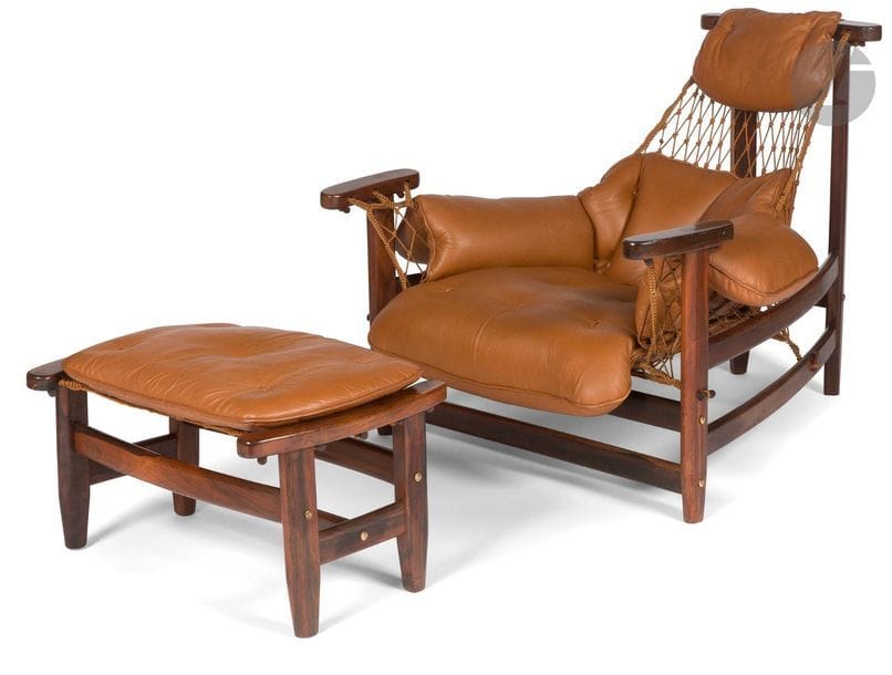 JEAN GILLON (1919-2007) DESIGNER & WOODART ÉDITEUR
Rare et intéressant fauteuil de repos et son ottoman en jacaranda. Suspentes des assises et du dossier constituées de filets. Coussins des assises, du dossier et des accotoirs en cuir brun d'origine. Étiquette d'éditeur sous une des traverses du fauteuil. Fauteuil : 83 x 89 x 106 cm - Ottoman :38 x 66 x 44 cm