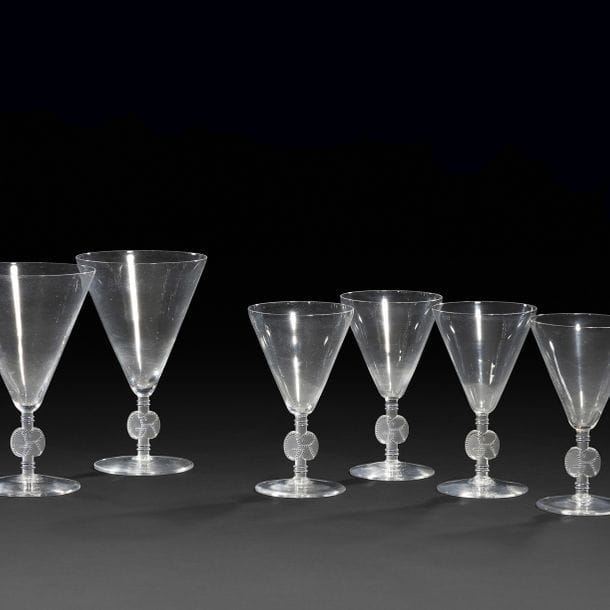 RENÉ LALIQUE (1860-1945) 
Suite de 6 verres à vin et 2 verres à eau. Épreuves en verre soufflé ; les jambes soulignées d'anneaux à l'émail noir, les pieds ornés des monogrammes GR également émaillés noir. Circa 1925/30. Chaque verre est signé R. LALIQUE France sous la base. H. 12,5 cm & 15 cm