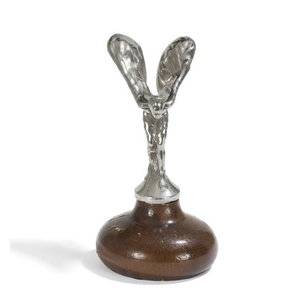 CHARLES ROBINSON SYKES (1875-1950)
Spirit of ecstasy, le modèle créé en [1911]
Mascotte Rolls-Royce formant bouchon de radiateur. Épreuve en métal argenté. Montée postérieurement sur un socle en bois. Marquée (r) ROLLS ROYCE Motors Limited 6/12/11 sur le pourtour de la base et porte l'inscription Trade Mark Reg à l'intérieur de l'aile gauche et Reg.Us.Pat.off à l'intérieur de l'aile droite. H. sujet seul : 14 cm - H. avec base métal et socle : 16,5 cm
NE PORTE PAS LES INSCRIPTIONS " Mark Reg et Reg. Us. Pat. off " A L'INTERIEUR DES AILES 