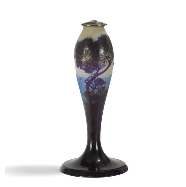 ÉTABLISSEMENTS GALLÉ (1904-1936) 
Pins et voiliers 
Pied de lampe balustre sur base circulaire. Épreuve en verre multicouche au décor, dégagé à l'acide, traité violet sur fond bleu et beige-jaune. Signé GALLÉ, en réserve gravé en camée à l'acide. H. verrerie seule : 34,5 cm