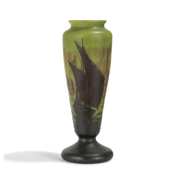 DAUM NANCY 
Voiliers 
Vase balustre sur piédouche. Épreuve en verre multicouche au décor, dégagé à l'acide, traité noir sur fond vert et ocre marmoréen. Signé DAUM Nancy à la Croix de Lorraine, en réserve gravé en camée à l'acide. H. 36 cm