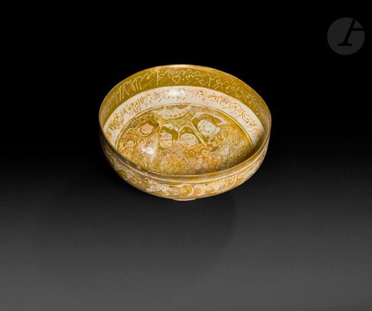 Grande coupe en céramique à décor de lustre métallique, Iran, seldjoukide, XIIIe siècle 
Coupe à panse carénée sur haut piédouche, en céramique siliceuse à décor de lustre métallique, orné au centre de quatre personnages à visage de lune et quatre oiseaux ceints de deux frises d’inscriptions cursives en persan sur le cavet et la paroi interne. Paroi externe ornée d’une frise d’animaux passants et d’une frise d’arbustes. 
Diamètre : 21 cm ; hauteur : 11 cm 
État : éclats, restaurations, nombreux repeints. 

A large Seljuk pottery bowl, Iran, 13th century