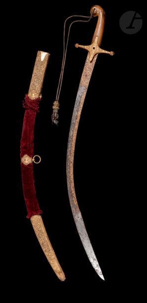 Sabre courbe, qilidj, Turquie ottomane, XVIIIe siècle 
Monture en crosse à plaquettes de corne ceinte d’une garniture en laiton moulé et garnie d’une lanière de fils métalliques à pampilles. Lame courbe damasquinée d’or et rehaussée de verre rouge offrant un décor de cartouches et médaillons épigraphiques entourés d’éléments floraux. Les inscriptions en arabe cursif sont des versets du Coran. Garde en laiton à deux quillons droits achevés en bouton, et oreillons losangiques à décor moulé de rinceaux végétaux. Fourreau en bois recouvert de velours pourpre à deux anneaux et garnitures en laiton à décor moulé de rinceaux végétaux et coquilles rocaille. 
Longueur avec fourreau : 96 cm 
État : velours déchiré, usure sur la crosse, lame altérée, parties mobiles. 

Bibliographie :
Alain Jacob, Les armes blanches du monde islamique, Paris : 1985, planches entre les pages 48 et 49 et en couverture. 

A saber, qilidj, with its velvet and brass scabbard, Ottoman Turkey, 18th century 