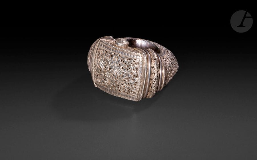 Important bracelet natla, Oman, Nizwa, XXe siècle 
En argent à décor ajouré et gravé de rinceaux floraux déployés sous des arcatures polylobées et encadré d’une frise d’ocelles. Fermoir charnière à tige. 
Diamètre extérieur : 12 cm ; diamètre intérieur : 6 cm, largeur max. : 8 cm ; poids : 502 g 
État : un choc.

Bibliographie :
Van Cutsem Anne, Bracelets ethniques d’Afrique, d’Asie, d’Océanie et d’Amérique, Paris, Skira : 2002, p. 145.

An important bracelet natla, Oman, Nizwa, 20th century