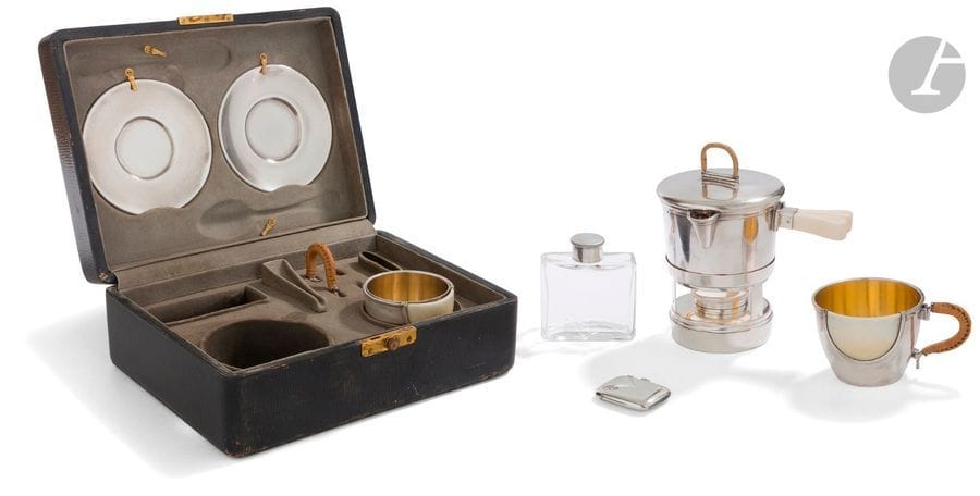 MALLETTE DE PIQUE-NIQUE POUR AUTOMOBILE : « AU TOURISTE 36 bis AVENUE DE L’OPéRA - PARIS » CIRCA 1920 - 1930
Dans sa mallette de transport, service à café en argent doublé de vermeil, inclusions d’ivoire et anses clissées. Il est composé de deux tasses doublées et leurs soucoupes, un réchaud à alcool et sa casserole, un porte-allumettes et un flacon en cristal. 
État : manque la doublure amovible d’une des tasses et les deux cuillers à moka
Poids brut : 831,30 g 