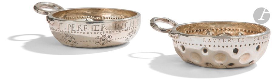 DEUX TASSES à VIN ATTRIBUéES AU PUY-DE-DOME 
En argent, l’une à anse à têtes de serpents affrontés (138,80 g) gravé au repoussé d’un décor d’ocelles et de rangs de points au revers et sur le pourtour : F. PERRIER D. CH. D. Traces de poinçons illisibles mais probablement du XVIIIe siècle, repoinçonnée au crabe, la seconde du XIXe siècle, repoussée de cupules et gravée : A. LAVALETTE SAUREL DE COURNON. Ancienne restauration (122,80 g). Repoinçonnée au sanglier. 