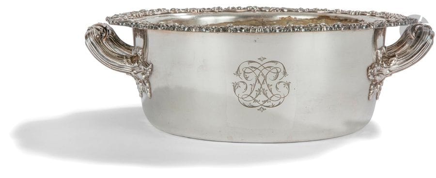 LéGUMIER ET SA DOUBLURE EN MéTAL ARGENTé
De forme ronde, il est mouluré de rinceaux feuillagés et coquilles sur le pourtour, les deux anses à larges attaches de feuilles de vigne. Travail français vers 1830 sans poinçon
Diamètre sans les anses : 23 cm - hauteur : 8 cm 