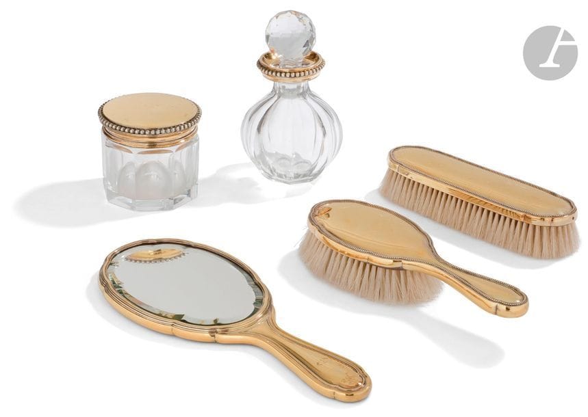 TéTARD FRèRES
Nécessaire de toilette en vermeil comportant : un flacon en cristal taillé et son bouchon, une boîte en cristal taillé de même, un miroir à main et deux brosses. 
Poinçon minerve
Poinçon d’orfèvre - porte un numéro de série - 
Poids brut : 1949,30 g 